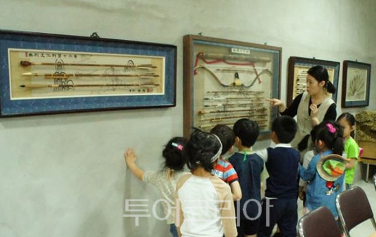아이들이 광양궁시전수교육관에서 작품 설명을 듣고 있다.