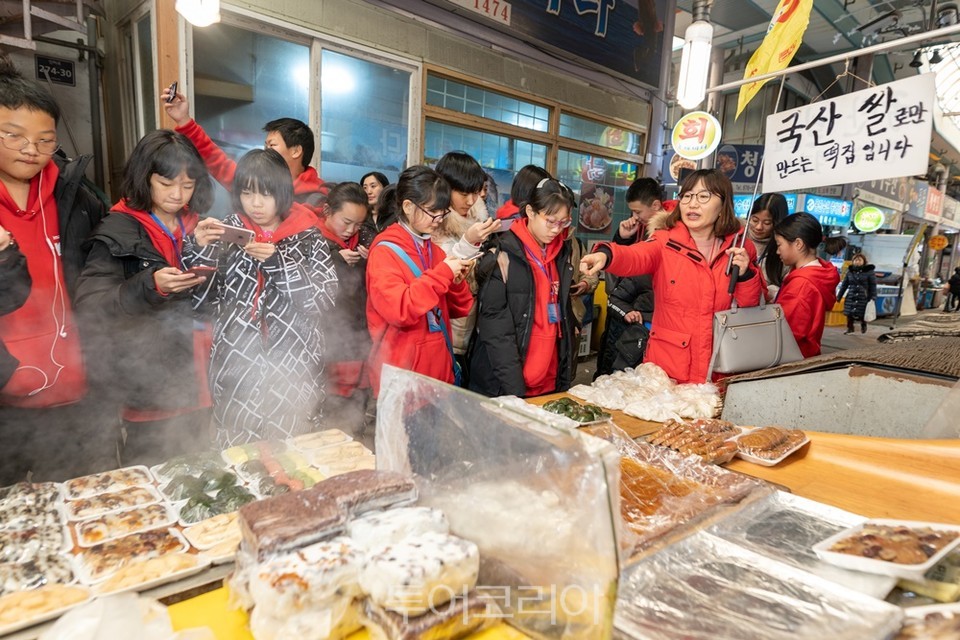 ​중국 수학여행단이 인천 시장을 찾아 한국의 전통의 맛을 체험하고 있다.